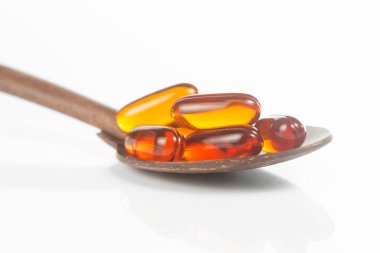 Beyaz zemin üzerinde lecithin / vitamin takviyeli kapsüller