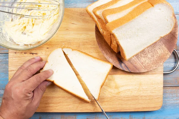 Chef holding knife cutting slide bread making on wooden  board/bake parmesan cheese toast by pan concept