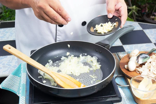 厨师把切碎的大蒜放进锅内 准备烹调蘑菇奶油汤 烹调蘑菇奶油汤 — 图库照片