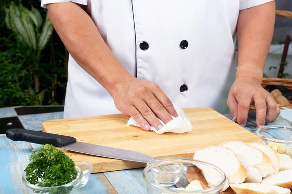 厨师用纸巾清洁木地板 烹调大蒜面包概念 — 图库照片