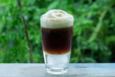 Kök birası yeşil ağaç arka planında lezzetli bir yaz ziyafeti sunar