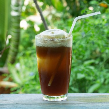 Kök birası yeşil ağaç arka planında lezzetli bir yaz ziyafeti sunar