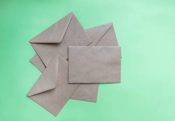 Крафт бумажные конверты на зеленом фоне — стоковое фото
