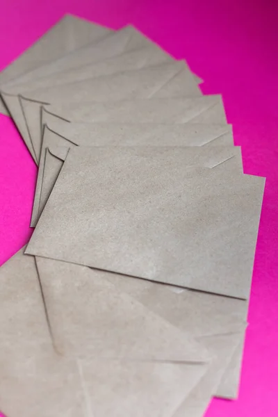 Papierowe koperty Kraft na fioletowym tle — Zdjęcie stockowe