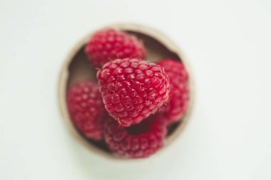 Ahşap bir tabakta taze ahududular.