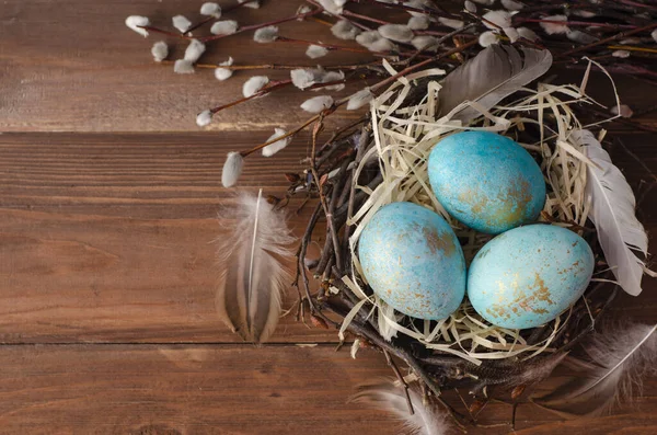 Mavi arka planda bir yuvada paskalya yumurtaları. Boşluğu kopyala, Ester bayramı kartpostal kavramı.