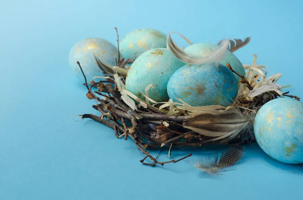 Paskalya geçmişi. Mavi arka plandaki yuvada Paskalya yumurtaları.