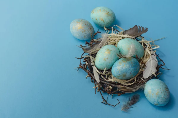 Paskalya geçmişi. Mavi arka plandaki yuvada Paskalya yumurtaları.