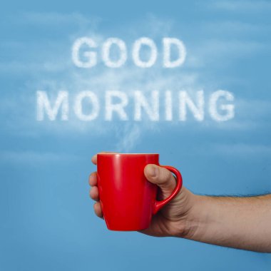 Günaydın, içki konsepti. Mavi arka planda dumanlı bir fincan sıcak kahve..