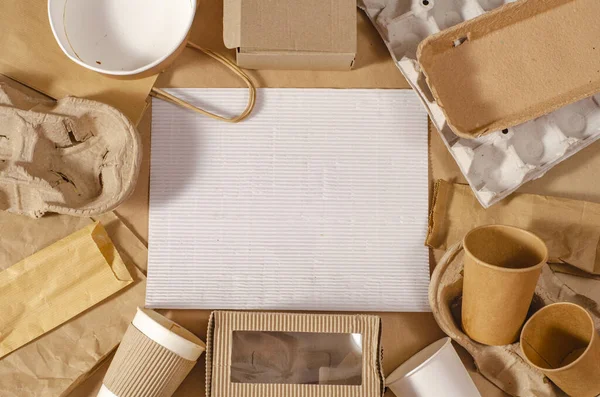 Eco craft paper tableware. Paper cups, dishes, bag, fast food containers, box for delivery food and wooden cutlery on craft background. Recycling concept. Zero waste.