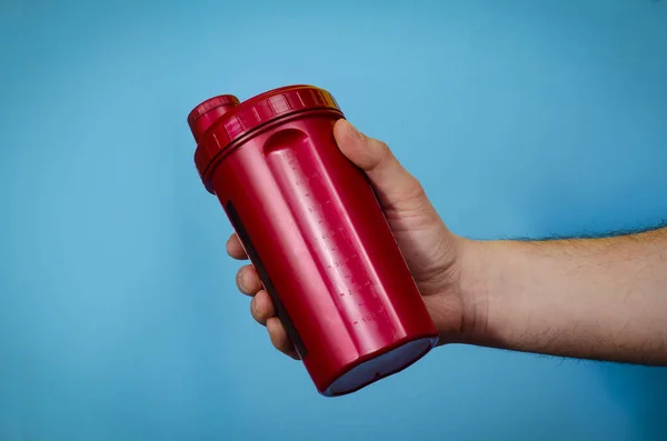 Mavi arka plan izolasyonunda kırmızı spor proteini karıştırıcısı  