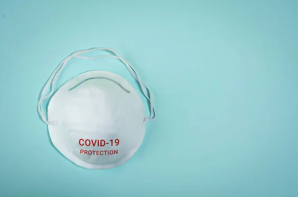 Mavi arka plandaki yüzün virüs ve bakterilere karşı tıbbi koruyucu maskesi