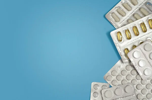 Mavi arka planda izole edilmiş kapsül haplarının tıbbi konsepti. Çeşitli renkli haplar ve kapsüller yakın, yatay, kopyalama alanı, seçici odak, tıbbi konsept. 