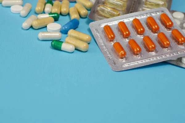 Mavi arka planda izole edilmiş kapsül haplarının tıbbi konsepti. Çeşitli renkli haplar ve kapsüller yakın, yatay, kopyalama alanı, seçici odak, tıbbi konsept. 