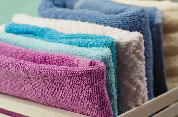 Hasır sepette farklı renkte banyo havluları. Arka planda. Kapat.