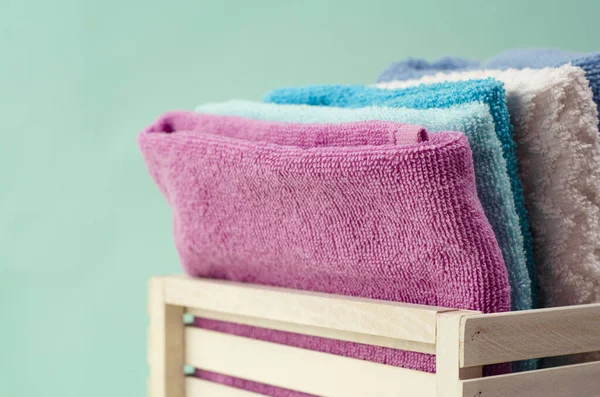 Πετσέτες Μπάνιου Διαφόρων Χρωμάτων Ψάθινο Καλάθι Στο Φως Φόντο — Φωτογραφία Αρχείου