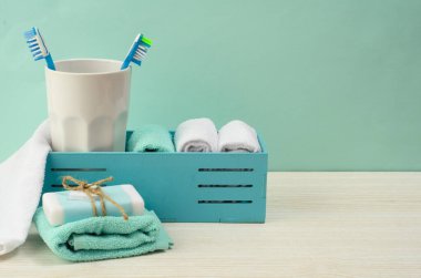 Turkuaz banyo. Beyaz bir pamuk havlu, turkuaz arka planda kavanozda diş fırçası. Kişisel bakım kavramı