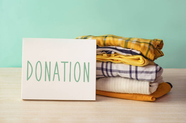 Donation concept. Donation box with donation clothes on a wooden background. Charity. Help for people in need