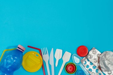 Mavi arka planda beyaz, tek kullanımlık plastik ve diğer plastik eşyalar. Plastik ya da çevresel sorunlar olmadan tercih etme kavramı.