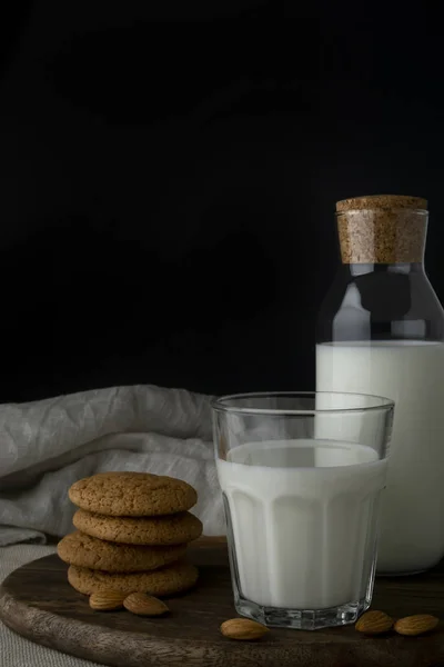Copo de leite, biscoitos, garrafa de leite e amêndoas — Fotografia de Stock