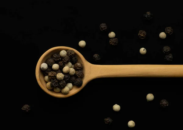 Miscela di peperoni su fondo nero e in cucchiaio di legno — Foto Stock