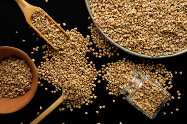 Plates of spoons and other cookware with buckwheat groats