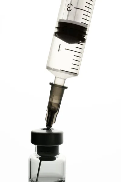 Disposable plastic syringe with needle inserted into medical ampoule — Stok fotoğraf