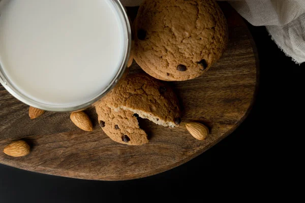 Haver koekjes met chocolade, amandel, melk in een glas op snijplank. Uitzicht van bovenaf — Stockfoto