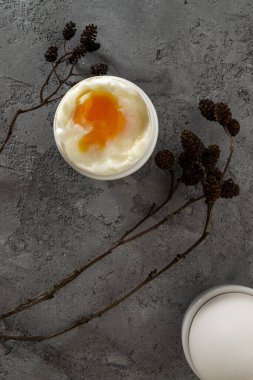 Yumurta kabında kaynamış yumurta ve kızılağaç külahlı beyaz tavuk yumurtası. Beton yüzeyde. Düz yatıyordu