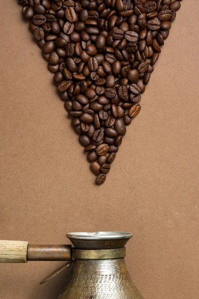 Grains de café en forme de flèche et une cafetière turque — Photo