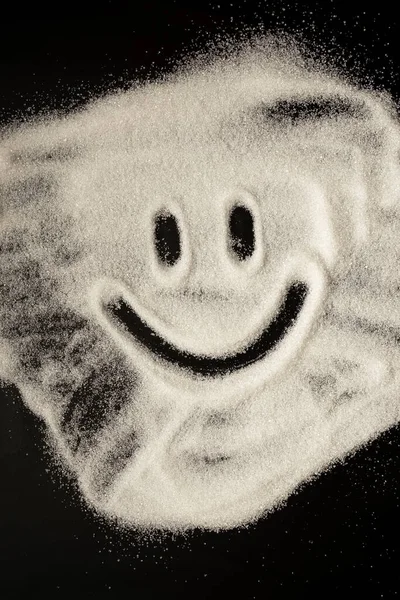 검은 상 위에서 설탕으로 그린 미소 이모티콘 — 스톡 사진