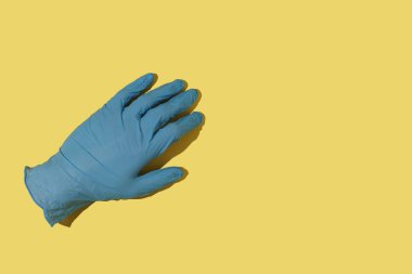 Sarı arka planda eli olmayan tıbbi eldiven..