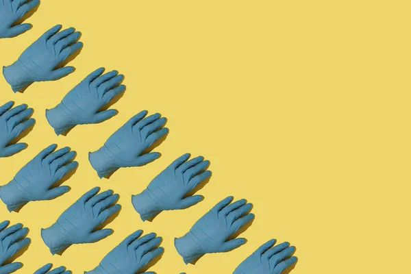 黄色背景的蓝色医用橡胶手套 — 图库照片