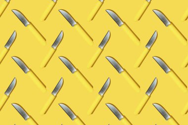 Sarı arka planda sarı saplı mutfak bıçakları, renkli desenler.