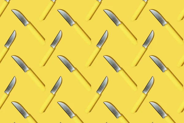 Noże kuchenne z żółtym uchwytem na żółtym tle, kolorowy wzór — Zdjęcie stockowe