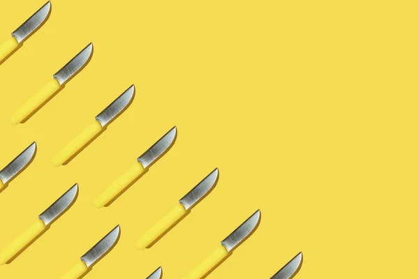 Halbrahmen-Küchenmesser mit gelbem Griff auf gelbem Hintergrund, buntes Muster — Stockfoto