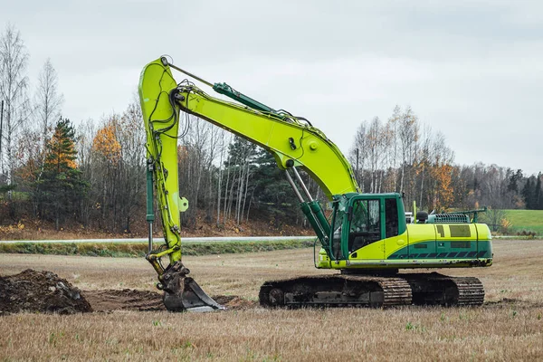 Modern excavator performs excavation work on the farm field.