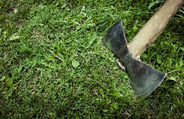 Yeşil çimlerin üzerinde eski bir balta