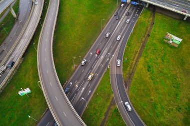 Şehir otobanının kavşaklarında havadan manzara. Araçlar yolda sürücü