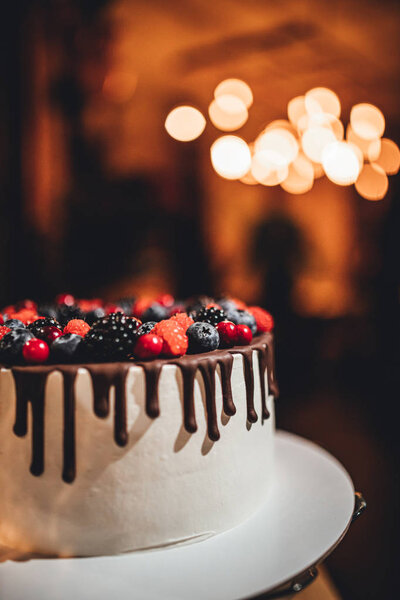 White cake with chocolate glaze and berrys, birthday cake in close up