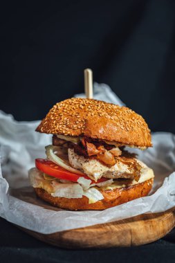 Domuz pastırmalı, domatesli, soğanlı ev yapımı tavuk fileto köftesi ve ahşap tabakta Sezar çorbası..