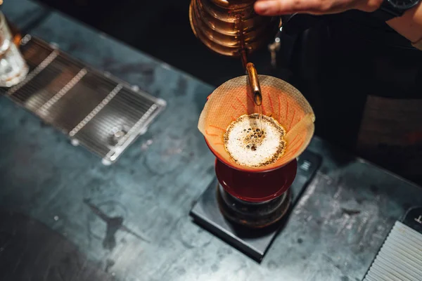 Barista brewing filter coffee in coffee shop