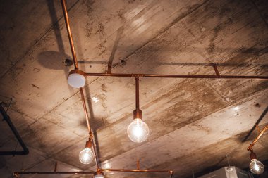 Beton tavandan sarkan klasik ampuller, modern iç mekan.