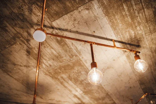 View on vintage light bulbs hanging from concrete ceilings, modern interior element