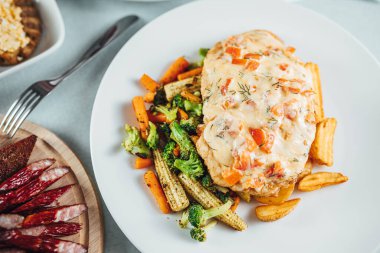 Patates ve sosla kaplı lezzetli kızarmış sebzelerden yakın çekim.