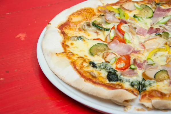 Gorąca pizza slice z topnienia ser. na czerwony drewniany stół. — Zdjęcie stockowe