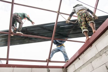 Çatı inşaat işçileri sac çatıya yükleyin..