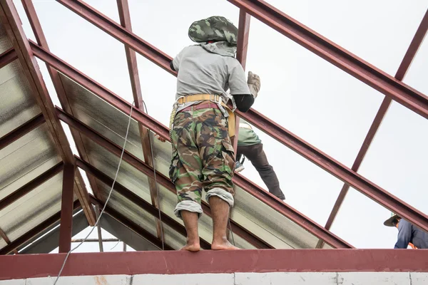 Takläggning byggnadsarbetare installerar plåt på taket. — Stockfoto