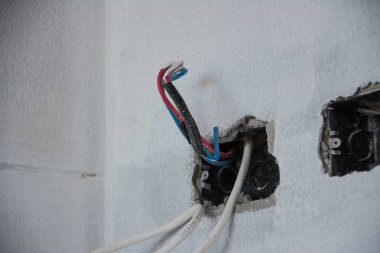İnşaat alanındaki duvarda elektrik sistemi, demir boruları olan bir priz.