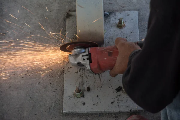 Arbeiter schneidet mit einem elektrischen Gerät ein Metallrohr — Stockfoto
